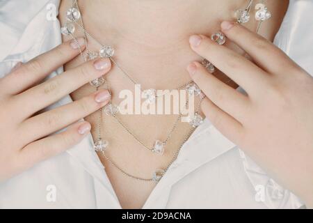 Junge Frau trägt Kristall Halskette, Ernte Ansicht. Silber-Kette mit vielen Kristallen. Stilvolle einfachen Stil der Bijouterie. Casual Accessoires. Stockfoto