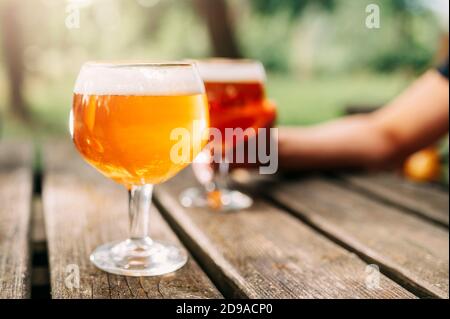 Glas Bier auf Holztisch im Freien. Stockfoto