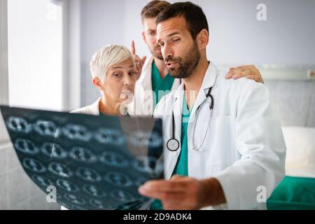 Gruppe von Ärzten, die Röntgenaufnahmen in einem Krankenhaus überprüfen. Stockfoto