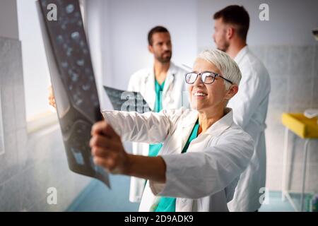 Gruppe von Ärzten, die ein Röntgenbild im Krankenhaus untersuchen, um die Diagnose zu stellen Stockfoto