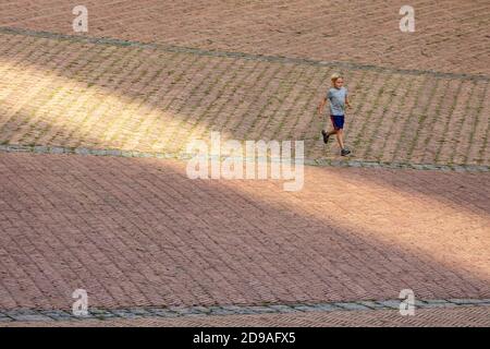 Ein junger blonder Junge läuft auf der Piazza del Campo, Siena, Toskana, Italien Stockfoto