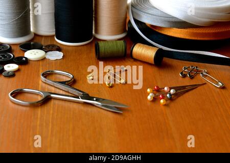 Eine Nahaufnahme ein kleines Paar silberne Nähschere unter einer Reihe von Nähzubehör. Stockfoto