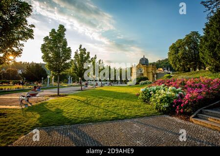 Marianske Lazne / Tschechische Republik - 8. August 2020: Blick auf die Kolonnade von Maxim Gorki und den singenden Wasserbrunnen. Bunte Blumen, grüner Rasen. Stockfoto