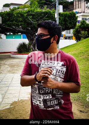 Vertikales Porträt eines jungen Mannes, der eine Gesichtsmask trägt Stockfoto