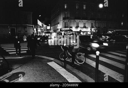 PARISER STRASSENFOTOGRAFIE - ZEBRA CROSIING SZENE IN PARIS BOULEVARD DE LA TOUR MAUBOURG BEI NACHT - SILBERFILM © F. BEAUMONT Stockfoto