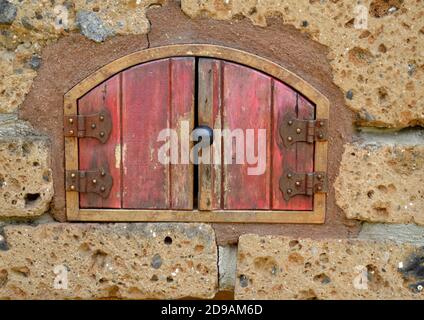 Kleine re Tür in Steinmauer gesetzt. Stockfoto