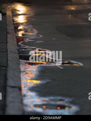 Die Sonne in den Pfützen. Abstrakte Fotografie Spiegelung der Abendsonne auf dem Asphalt Stockfoto