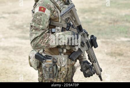 Soldat mit Sturmgewehr und Flagge Vietnams auf Militäruniform. Collage. Stockfoto