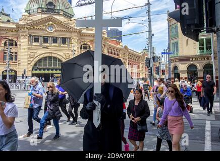 Ein christlicher Evangelist zieht mit seinem Kreuz durch die Straßen Melbournes. Stockfoto