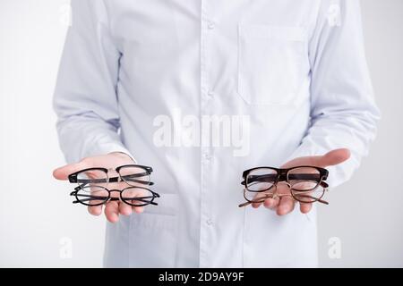 Beschnittene Ansicht des Arztes mit zwei Brillen auf den Handflächen Isoliert auf Weiß Stockfoto