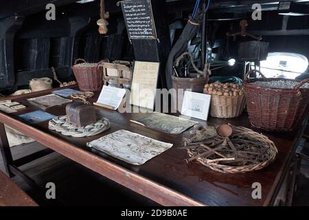 Alte hölzerne Schiffsvertäfelei mit Essen, Karten und Truhe Stockfoto