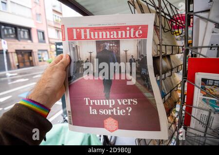 Paris, Frankreich - 3. Nov 2020: POV männliche Hand bei der Zeitung l'Humanite mit Cover, die zeigt, wie Trump während der Wahl zum US-Präsidenten zwischen Donald Trump und Joe Biden, demokratischer Kandidat, verlassen wird Stockfoto