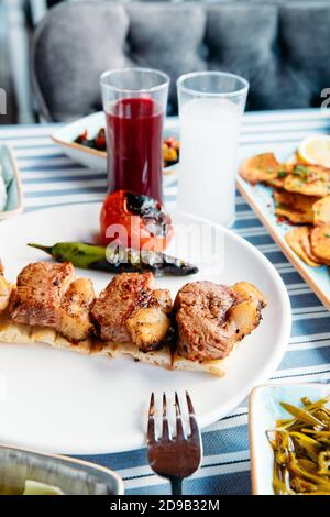 Gegrilltes Fleisch, Meeresfrüchte, Meze, Kräuter, Fisch, Raki, Ouzo, Vorspeisen und Salate im griechischen oder türkischen Restaurant auf dem Tisch zum Abendessen oder Mittagessen am Strand Stockfoto