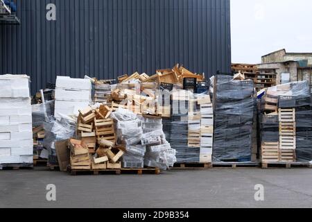 Stapel von Holz- und Kunststoffkisten im Lagerhaus im Lagerhof. Boxen und Container für den Transport von Produkten per LKW. Fracht und Versand in Geschäften Stockfoto