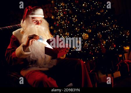 Überrascht Santa zieht aus einem Geschenk eine medizinische Maske und versteht nicht, was mit ihm zu tun. Stockfoto