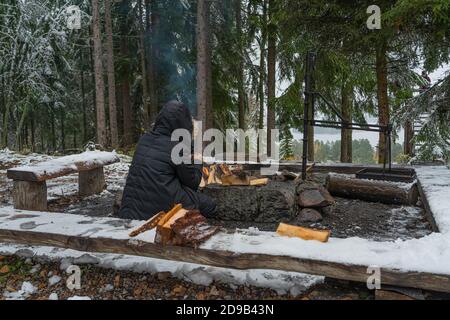 Asikkala, Finnland Finnland 21. Oktober 2020 Herbst. Erster Schnee, Touristen im Freien in der Natur. Wärmt seine Hände durch das Feuer. Reise- und Reisekonzept. Hochwertige Fotos Stockfoto