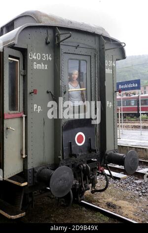 Sucha Beskidzka. Polen. Ein Passagier, der aus der Heckscheibe des letzten Wagens des alten Zuges schaut, der am Bahnhof steht. Stockfoto