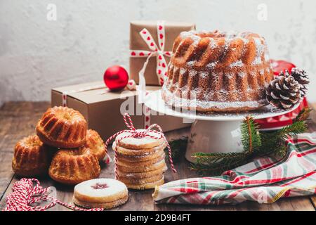 Auswahl an hausgemachten Weihnachtsdesserts und Geschenkschachteln auf einem Rustikaler Holztisch Stockfoto