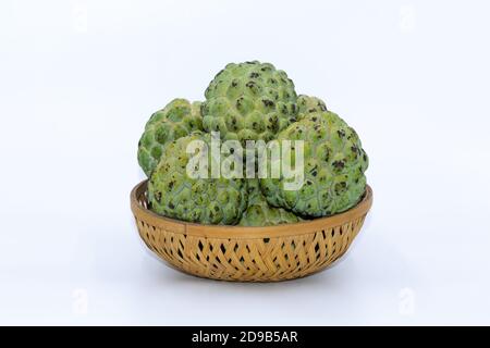 Frische grüne Custard Äpfel auf einem Holzkorb mit gehalten Weißer Hintergrund Stockfoto