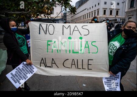 Madrid, Spanien. November 2020. Frauen halten ein Plakat mit der Aufschrift "Keine Familien mehr auf die Straße" während eines Protestes vor dem spanischen Parlament, um die Beendigung der Räumungen während des Coronavirus (COVID-19) Ausbruch zu fordern. Quelle: Marcos del Mazo/Alamy Live News Stockfoto