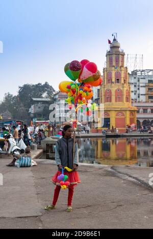 Mädchen verkaufen bunte Ballon Kunst in der Nähe Ufer des Godavari Fluss, Nashik City, Maharashtra, Indien, von lokalen Menschen, Händler, Touristen, Obdachlose überfüllt Stockfoto