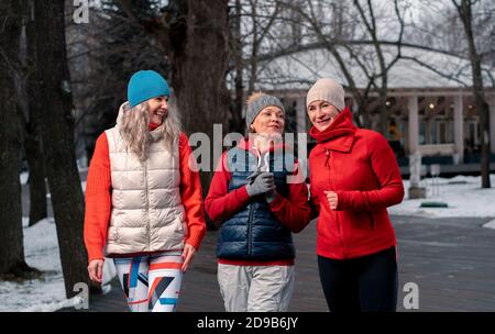 Freunde Reifer Frauen, Die Nach Dem Morgendlichen Lauf Im Park Spazieren Und Über Neuigkeiten Reden. Aktiver Lebensstil Und Freundschaft im Mittelalter. Stockfoto