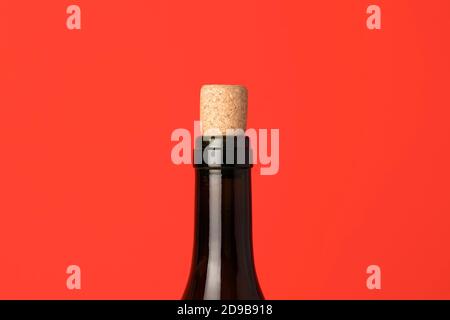 Nahaufnahme der Weinflasche mit Korken. Weinkappe auf rotem Hintergrund. Minimalkonzept Stockfoto