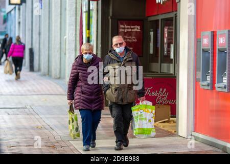 Birmingham, Großbritannien. November 2020. Ein älteres Paar trägt ihre Einkäufe durch das Stadtzentrum, während Großbritannien in eine weitere Sperre stürzt. Kredit: Ryan Underwood/Alamy Live Nachrichten Stockfoto