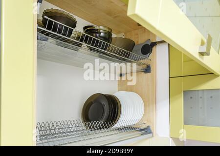Set von Tellern, Tassen auf dem Regal im Küchenschrank Stockfoto