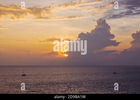 Ruhiges Meer mit Sonnenuntergang Himmel und Sonne durch die Wolken über. Meditation Ozean und Himmel Hintergrund Stockfoto