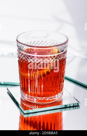 Orangenscheibe in gemischtem Alkohol Cocktail auf Weiß