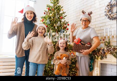 Frohe Weihnachten und schöne Feiertage! Oma, Mama und Töchter in der Nähe des Baumes drinnen. Der Morgen vor Weihnachten. Porträt der liebevollen Familie. Stockfoto