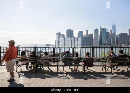 NEW YORK, USA - 27. Apr 2016: Skyline von Manhattan von der Brooklyn Heights Promenade. Die Menschen entspannen sich und genießen die atemberaubende Aussicht auf Manhattan Stockfoto