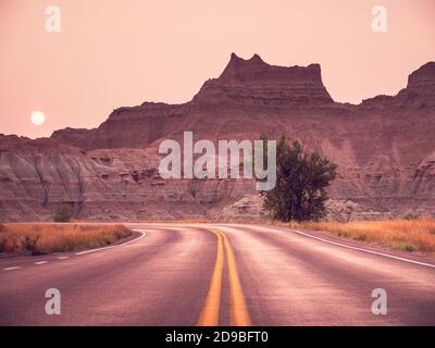 Badlands National Park Road bei Sonnenuntergang bei Waldbränden, South Dakota, USA Stockfoto
