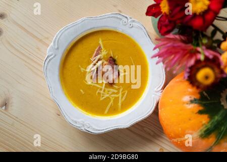 Blick von oben auf die Kürbiscremesuppe mit Speck und Käse Stockfoto