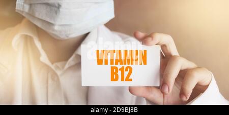 Vitamin B12 auf einer Karte in den Händen der Ärzte geschrieben. Medizinisches Gesundheitskonzept Stockfoto