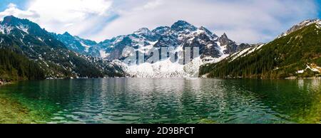 Hohe felsige Berge und kristallklares türkisfarbenes See hochauflösendes Panorama. Tatra Nationalpark, ein See in den Bergen mit Schnee bedeckt. Stockfoto