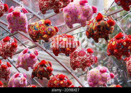 Rote und rosa flauschige Spielzeug Schwein Dekorationen hängen, für chinesische Neujahrsfeier, Jahr des Schweins, in Chinatown, Singapur. Stockfoto