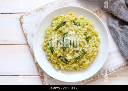Italienisches Risotto mit Frühlingsspargel und Parmesankäse auf hellem Hintergrund. Draufsicht mit Kopierbereich. Stockfoto