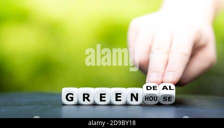 Hand dreht Würfel und ändert den Ausdruck "Gewächshaus" zu "Green Deal". Stockfoto