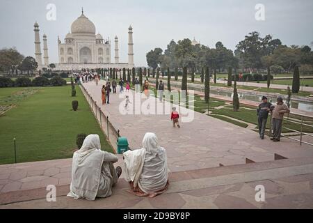 Agra, Indien, Januar 2009. Die Leute sitzen und schauen sich einen allgemeinen Blick auf das Taj Mahal von den Gärten an der Vorderseite an. Stockfoto