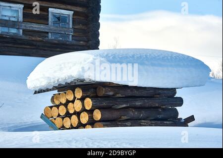 Ein Stapel von Baumstämmen mit Schiefer unter dem Schnee bedeckt Stockfoto