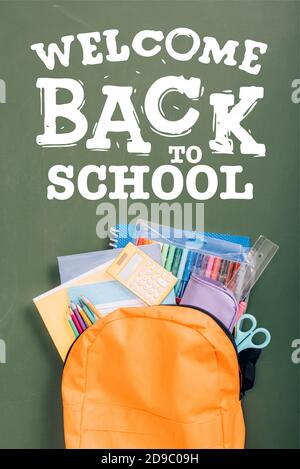 Draufsicht auf Rucksack mit Schulpapiere auf grün verpackt Kreidetafel mit Welcome back to School Schriftzug Stockfoto