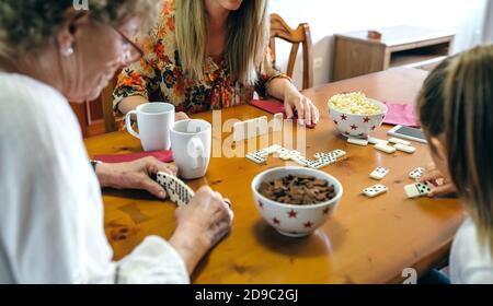 Drei weibliche Generationen spielen Domino Stockfoto