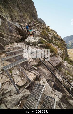 Touristen auf Metalltreppen, Leitern und Ketten auf dem Weg zum Rysy Peak, hohe Tatra, Slowakei. Stockfoto