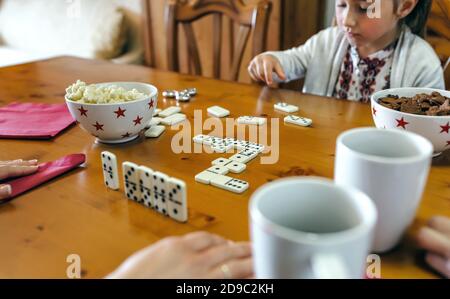 Mädchen spielen Domino mit ihrer Familie Stockfoto