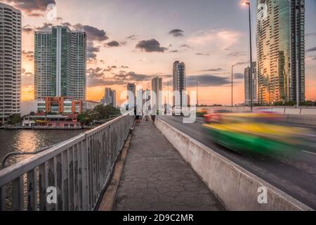 Verkehr auf der Taksin Brücke über den Chao Phraya Fluss in Bangkok, Thailand bei Sonnenuntergang Stockfoto