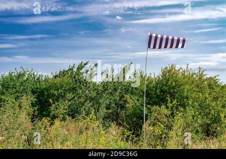 Blaue Wetterfahne Wetterfahne im kleinen Flughafen auf einem Hintergrund von grünen Bäumen Stockfoto