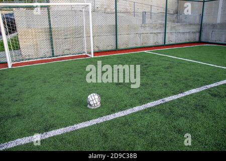 Fußball auf Kunstrasen hell und dunkelgrün Gras an Öffentlicher Outdoor-Fußball oder Futsal-Stadion Stockfoto
