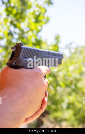 Ein Mann zielt auf seine halbautomatische Pistole. Stockfoto